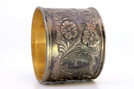 Argola de guardanapo em prata com relevos florais envolvendo cartela para monograma.